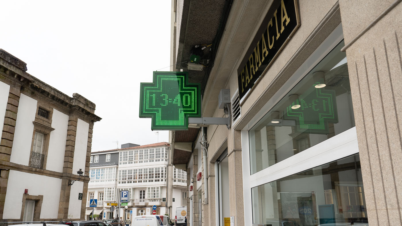 Cruz luminosa de Farmacia Leis con hora, fachada en Betanzos